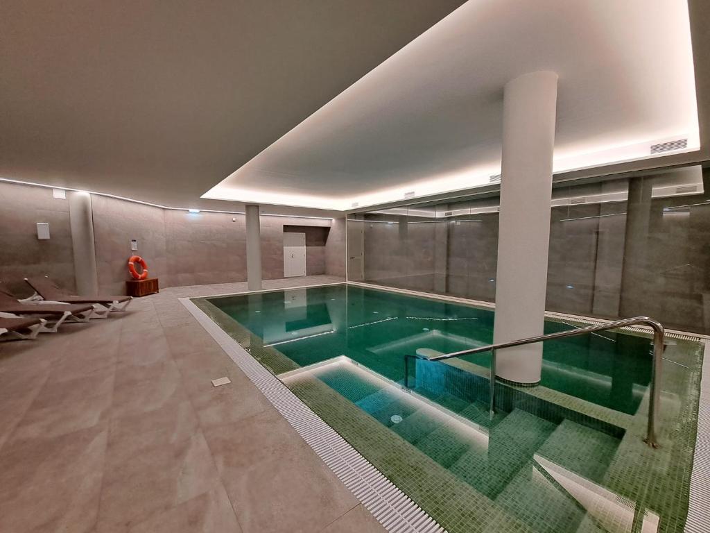 a large swimming pool in a building at Hotel Euro Moniz in Porto Moniz