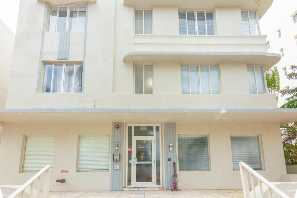 a white building with a door in front of it at Ocean Villa in Miami Beach
