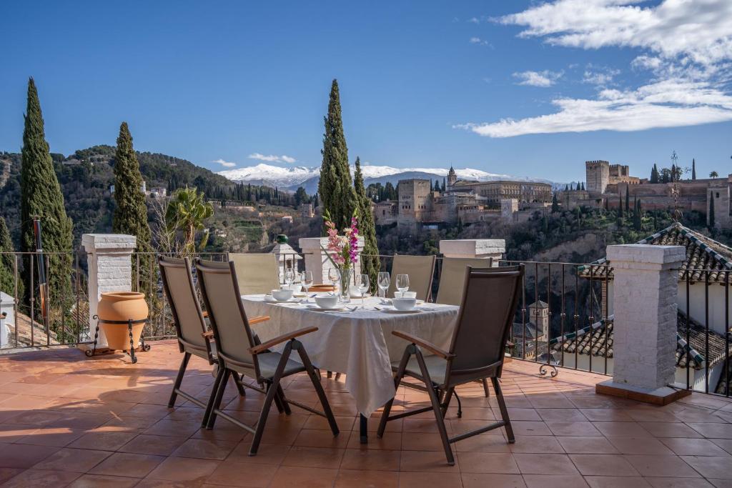 a table and chairs on a patio with a view at Carmen de los Moriscos - Alhambra views in Granada