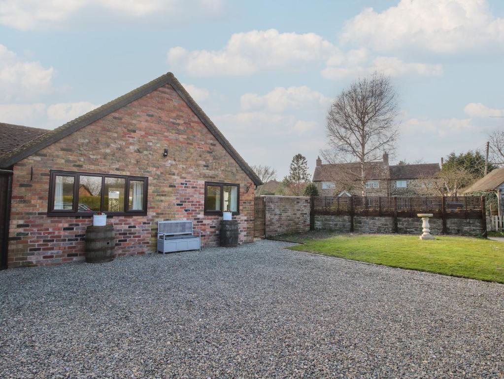 una casa de ladrillo con camino de entrada de grava en Blockley Lodge, en Church Stretton