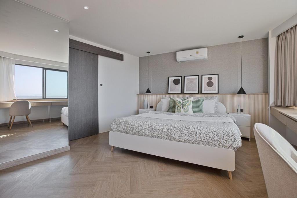 チェンマイにあるPenthouse Condo I Mountain Viewの白いベッドルーム(大型ベッド1台、デスク付)