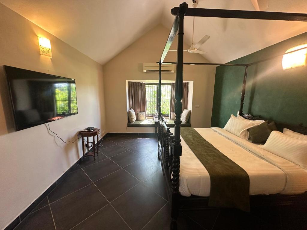 a bedroom with a bed and a tv in a room at Villa Bay by Youkoso in Chennai