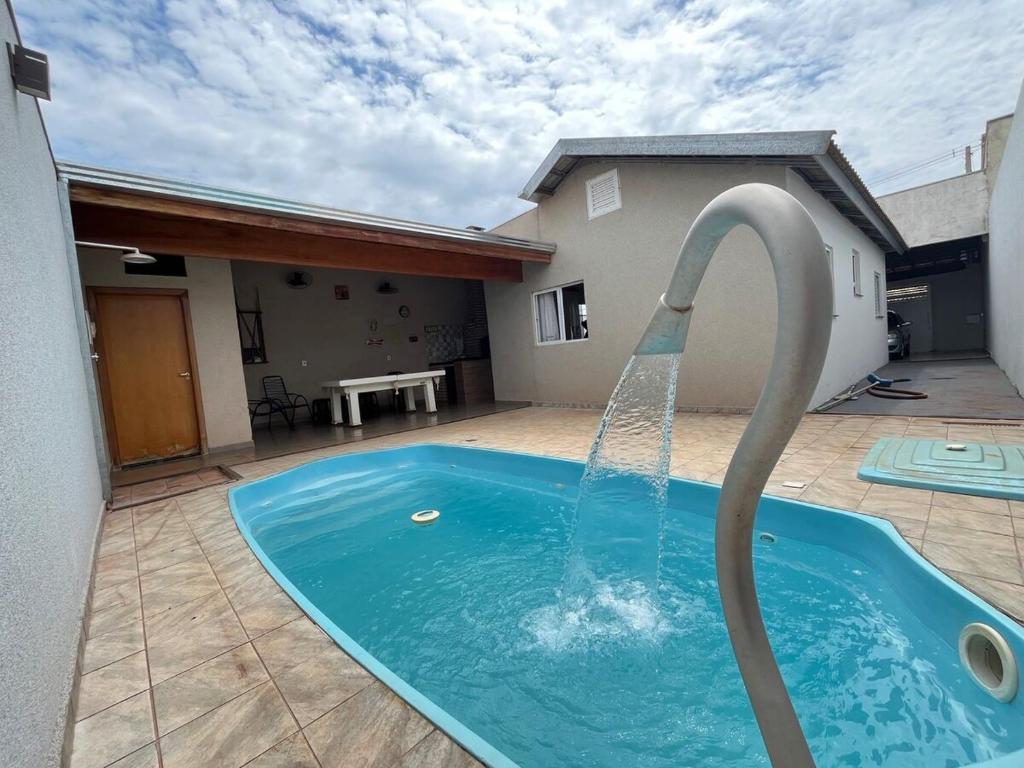 una piscina con una fuente de agua en un patio en Recanto Belmonte, en Olímpia