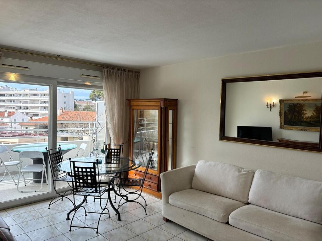 un salon avec un canapé et une table avec des chaises dans l'établissement La Croisette I T2, à Cannes