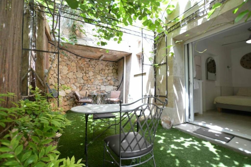 d'une terrasse avec une table et des chaises dans le jardin. dans l'établissement Unique havre de paix, à Nice