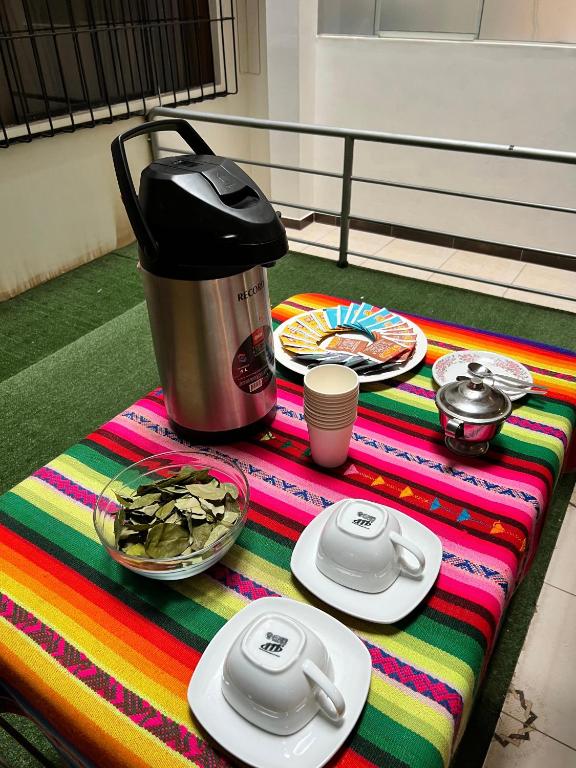 un tavolo con caffettiera e piatti di cibo di HAYLLI QOSQO Hotel Inn a Cuzco