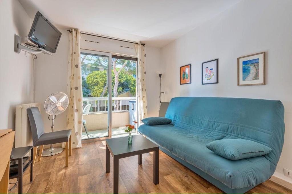 un salon avec un canapé bleu et une table dans l'établissement Le Petit Balcon, à Nice