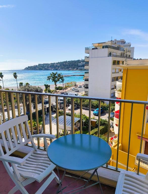 une table et des chaises sur un balcon avec vue sur la plage dans l'établissement Bright and spacious seaside studio, à Roquebrune-Cap-Martin