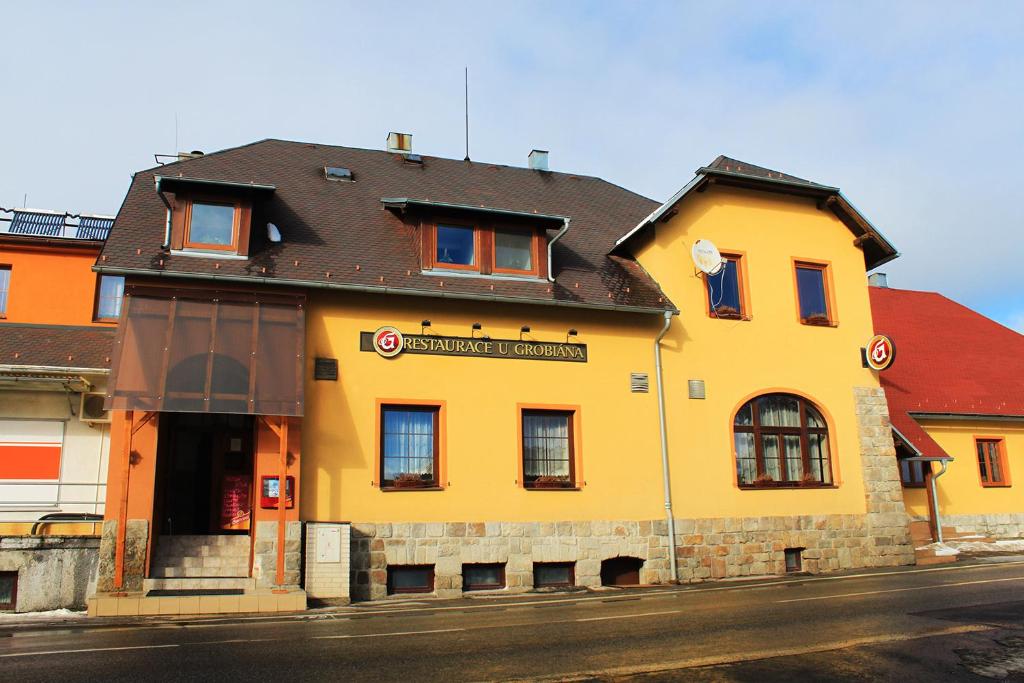 a yellow building on the side of a street at Penzion U Grobiana in Lenora