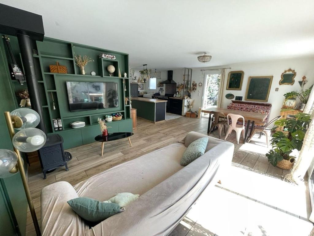 un salon avec un canapé et une télévision dans l'établissement Maison centre ville, à Craponne