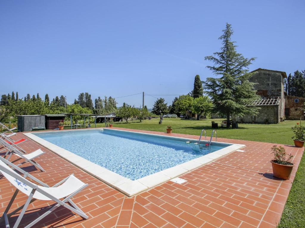 una piscina in un cortile con due sedie di Apartment Fattoria Petraglia - Terrazza by Interhome a Monteriggioni