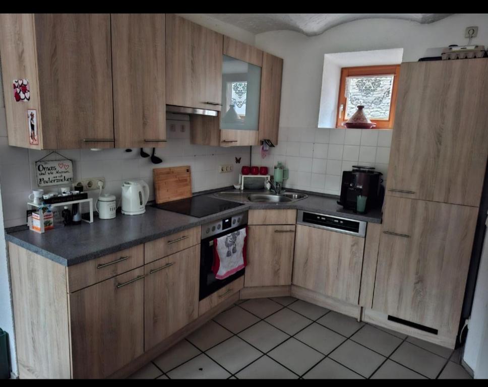 Una cocina con gabinetes de madera y un fregadero. en Ferienwohnung Zur Flomborner Wutz, en Flomborn