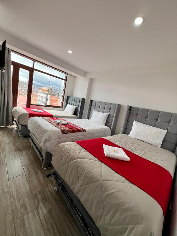 3 posti letto in una camera con finestra di HAYLLI QOSQO Hotel Inn a Cuzco