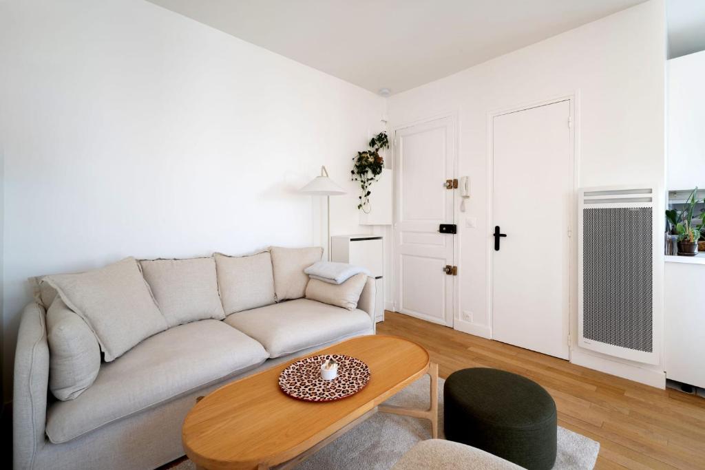 un salon avec un canapé et une table dans l'établissement Appartement Candie - Welkeys, à Paris