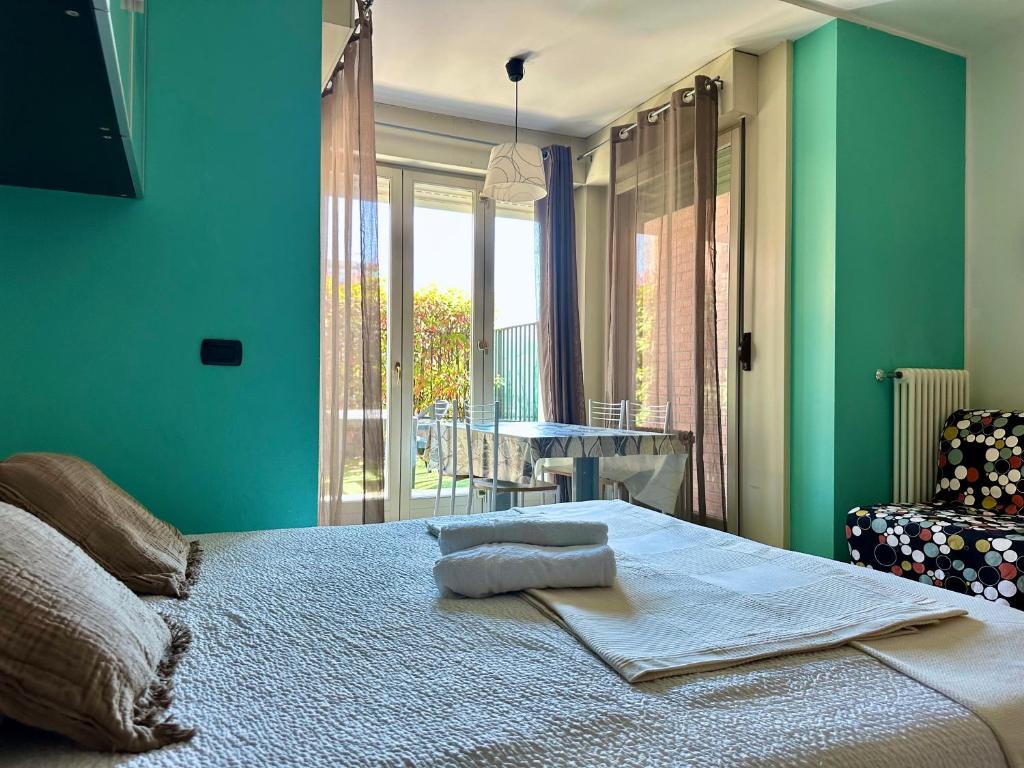 a bedroom with green walls and a bed with a chair at Il Borgo 6 in Bergamo