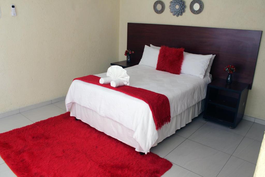 a bedroom with a large bed with a red blanket at Phendulani Lodge & Park in Calcutta