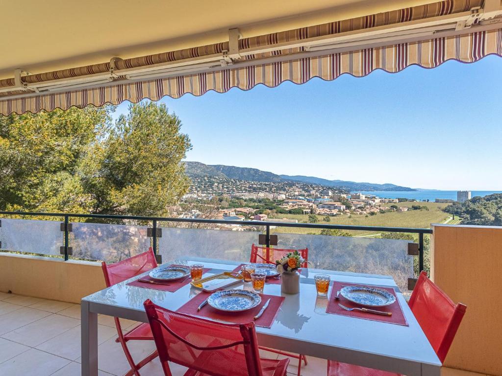 une table et des chaises sur un balcon avec vue dans l'établissement Apartment Le Bois du Coteau by Interhome, à Bormes-les-Mimosas