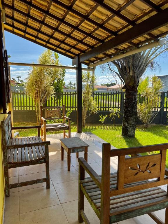 a patio with benches and a table and a fence at Refugio Brisa do Campo - IG - SOLAR DO CAMPO in Iguaba Grande