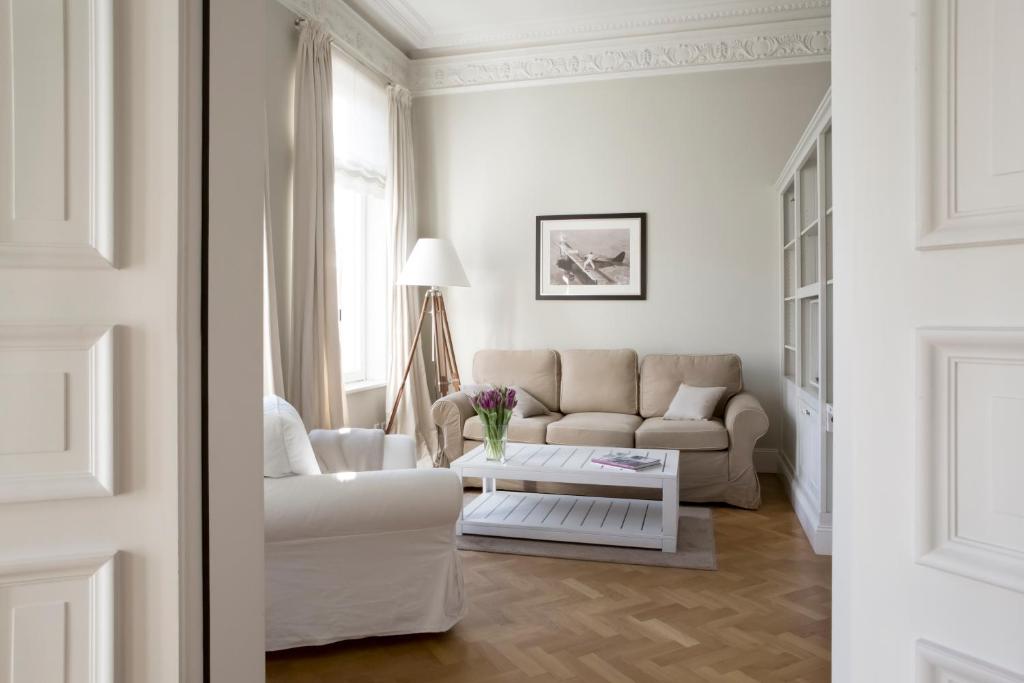 Sala de estar blanca con sofá y mesa en von Deska Townhouses - White House, en Hamburgo
