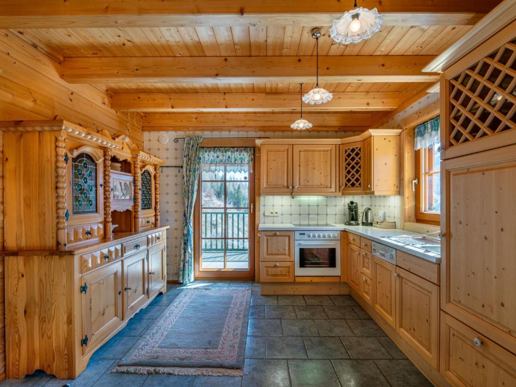 cocina grande con armarios de madera y ventana grande en Holiday Home Karin by Interhome, en Heiligenblut
