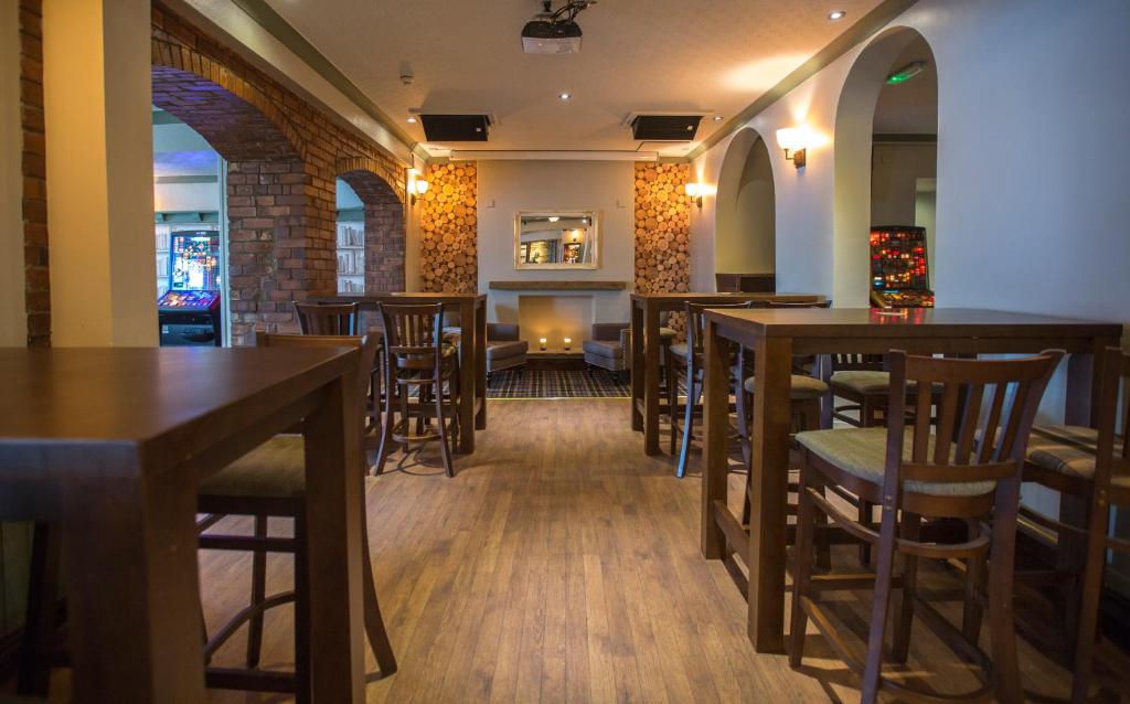 a bar with wooden tables and chairs in a restaurant at The Sun Inn in Ulverston