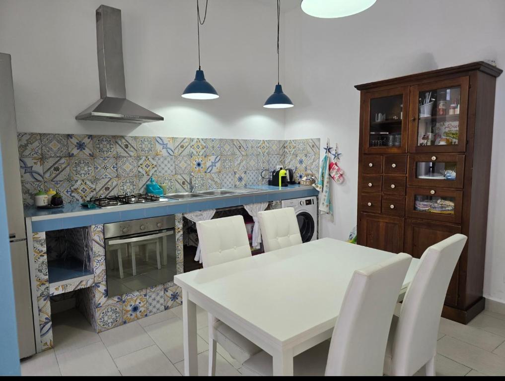a kitchen with a white table and a stove at CASA CASCIOTTO in Palermo