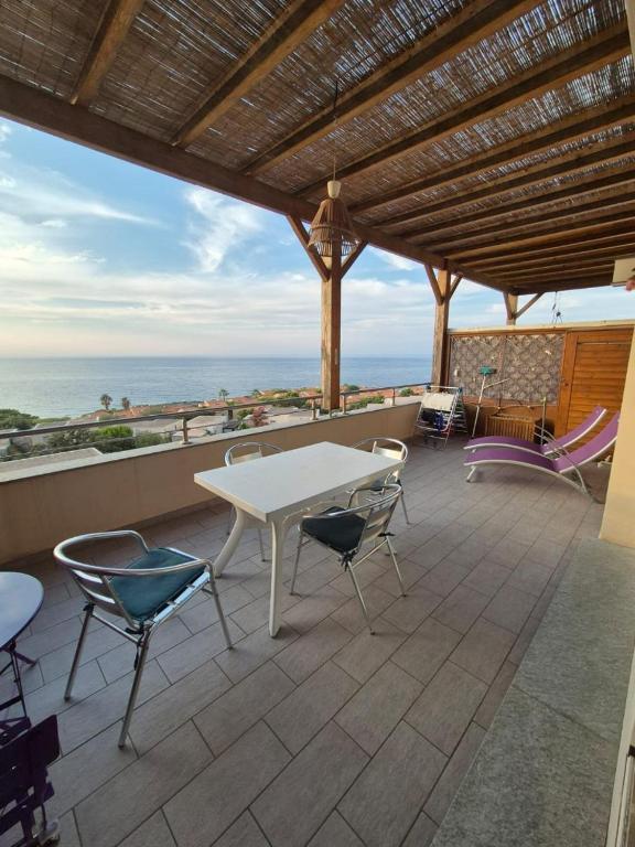 un patio avec une table et des chaises et l'océan dans l'établissement Appartement Marine de Sant Ambrogio, à Lumio
