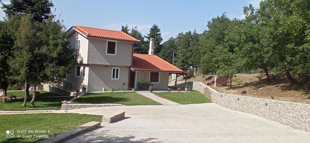 a house with a stone wall next to a driveway at Πολύμνια in Agia Anna
