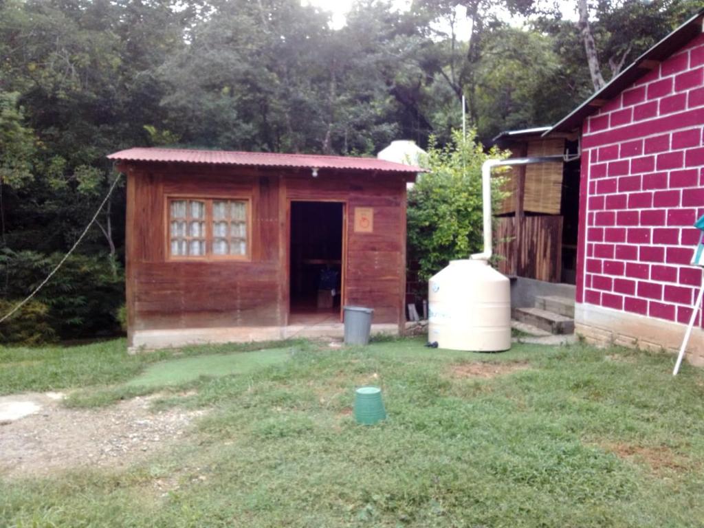 a small red brick building with a garage at Cabaña la ira in Santa Maria Huatulco