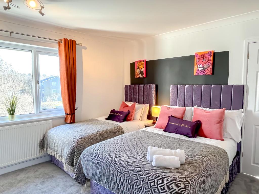 two beds in a room with purple and pink at ColleyHouse-private parking-business-group-relocation-SpaciousStylish 4BRHome-Sleeps 10 in Sheffield