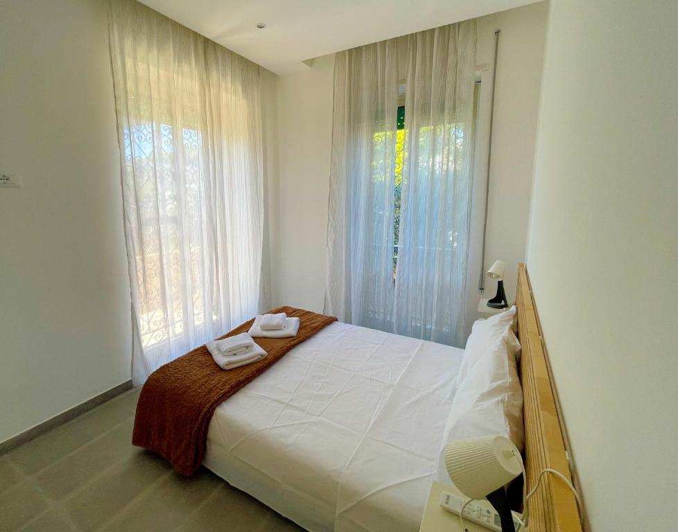 um quarto com uma cama com duas toalhas em K-FOFO Apartment - Steps from Anzio Station, Beach & Town Center em Anzio