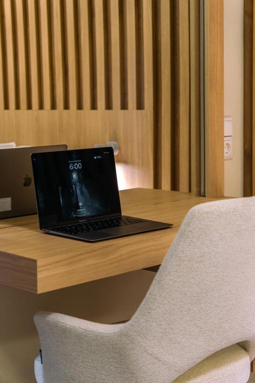 a laptop computer sitting on top of a wooden desk at Ioannina Center Apartment in Ioannina