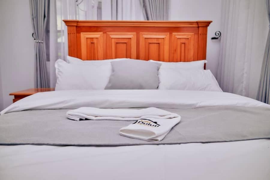 a pair of white towels sitting on top of a bed at Lake duluti serenity villas in Arusha