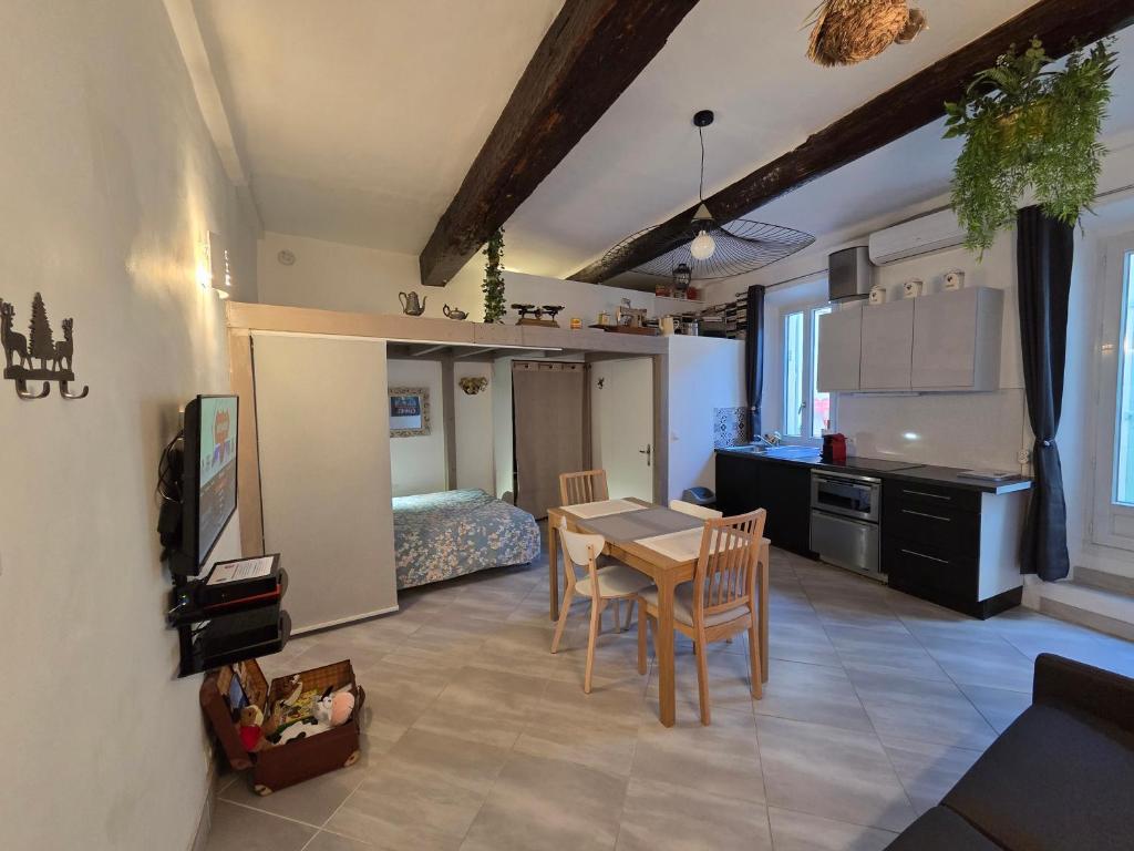 une cuisine et un salon avec une table et des chaises dans l'établissement Meynadier 66 - Appartement Très Calme avec Cour Privative, Plage, Gare, Palais à 300m, à Cannes