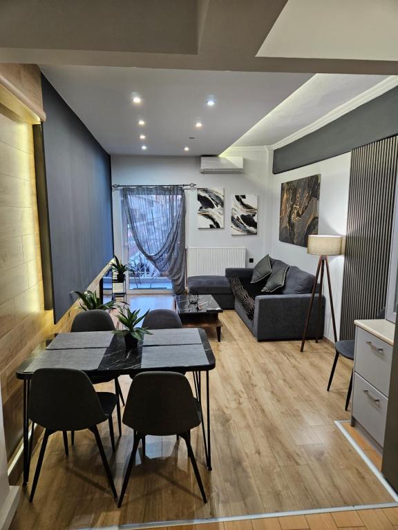 Una sala de estar con un sofá, una mesa y sillas. en Central 3 Modern Apartment with FREE parking, en Serres