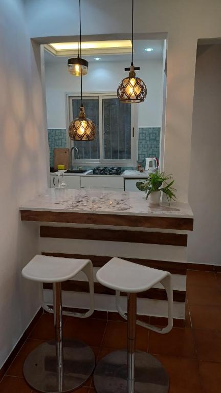 a kitchen with a counter with two stools and two lights at Irina Blessed Homes Bonanjo in Douala