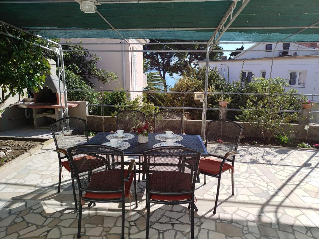 a table and chairs sitting on a patio at Cute apartment Arba in Rab