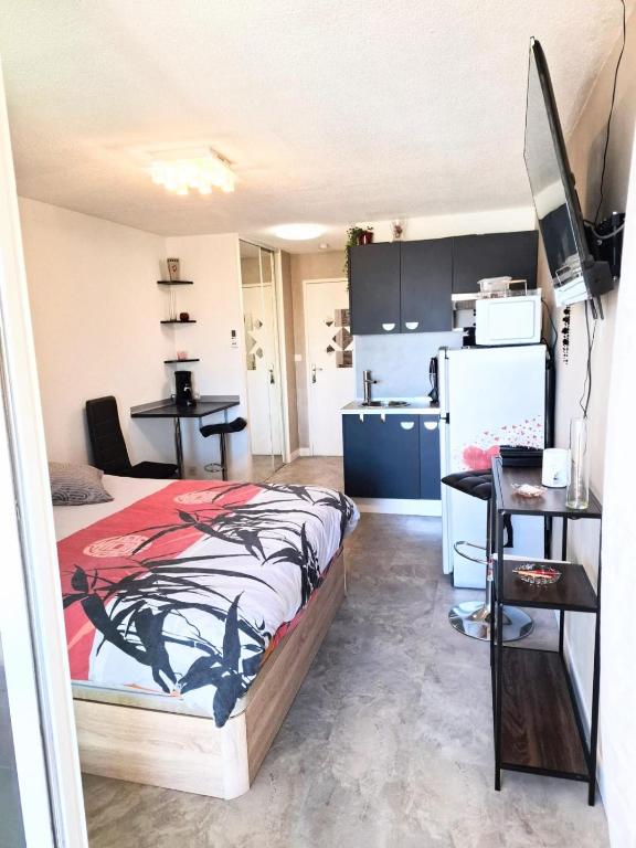 une petite chambre avec un lit et une cuisine dans l'établissement Naturiste Cap d'Agde Port Soleil 456, au Cap d'Agde
