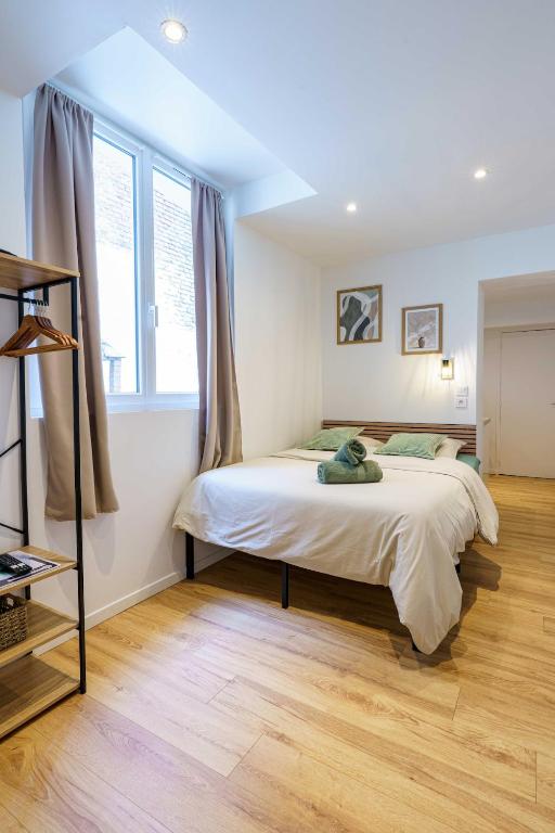 une chambre avec un lit et une grande fenêtre dans l'établissement Studio Détente 2 pers wifi gare, à Saint-Quentin
