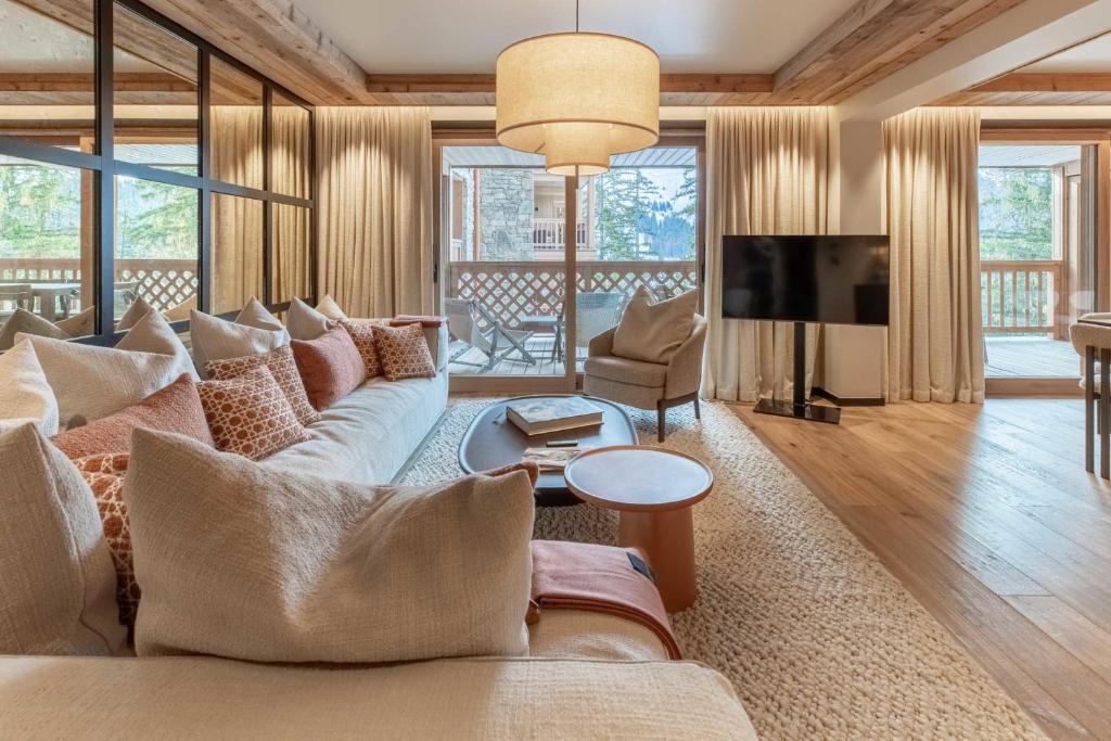 un salon avec un canapé et une télévision dans l'établissement Antarès URSA 303 - luxury apartment ski inski out, à Méribel