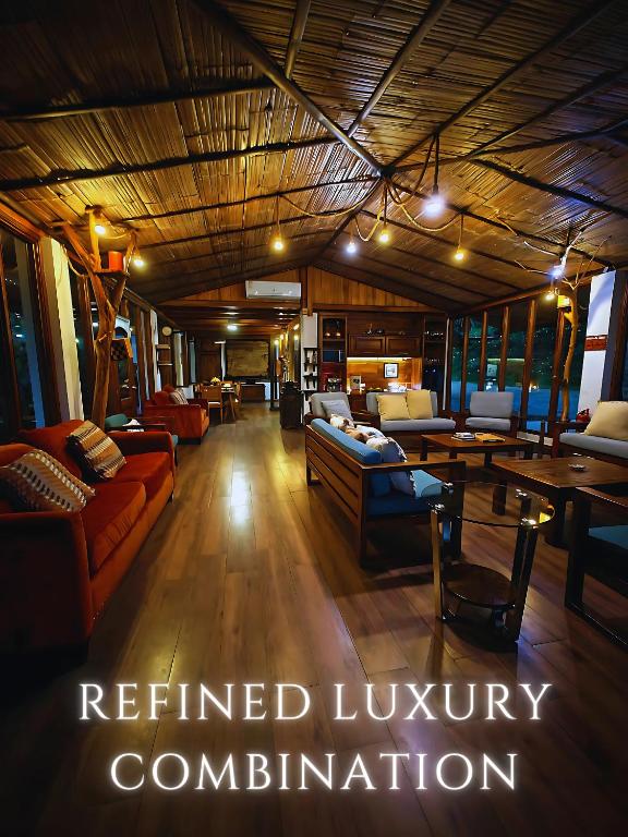 a living room with couches and tables in a room at The River House - Upscale Lodge in Puerto Quito
