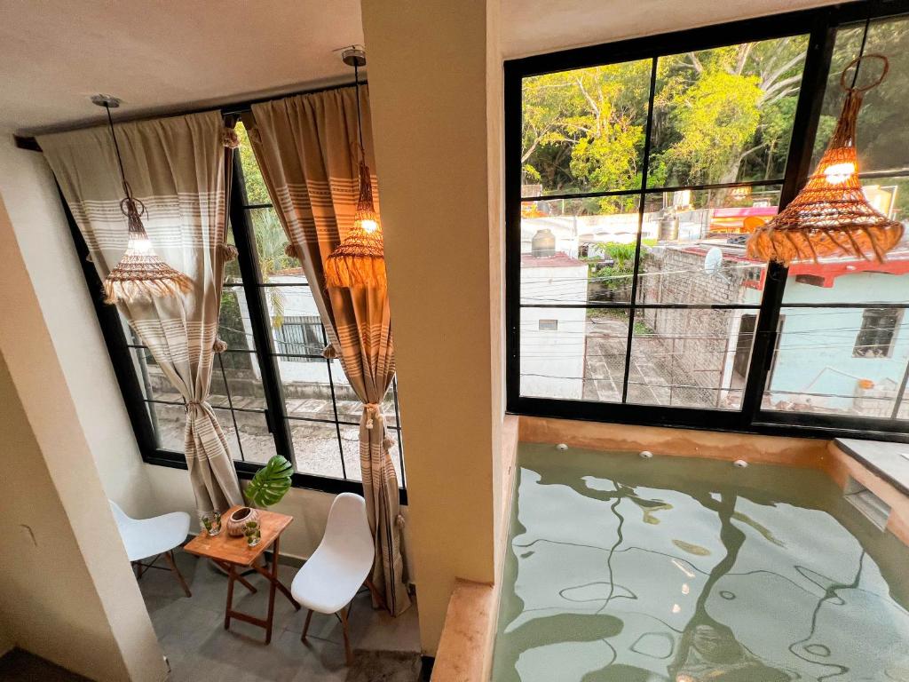 a house with a swimming pool in a room with windows at Bungalows Las Chachalacas in Los Ayala