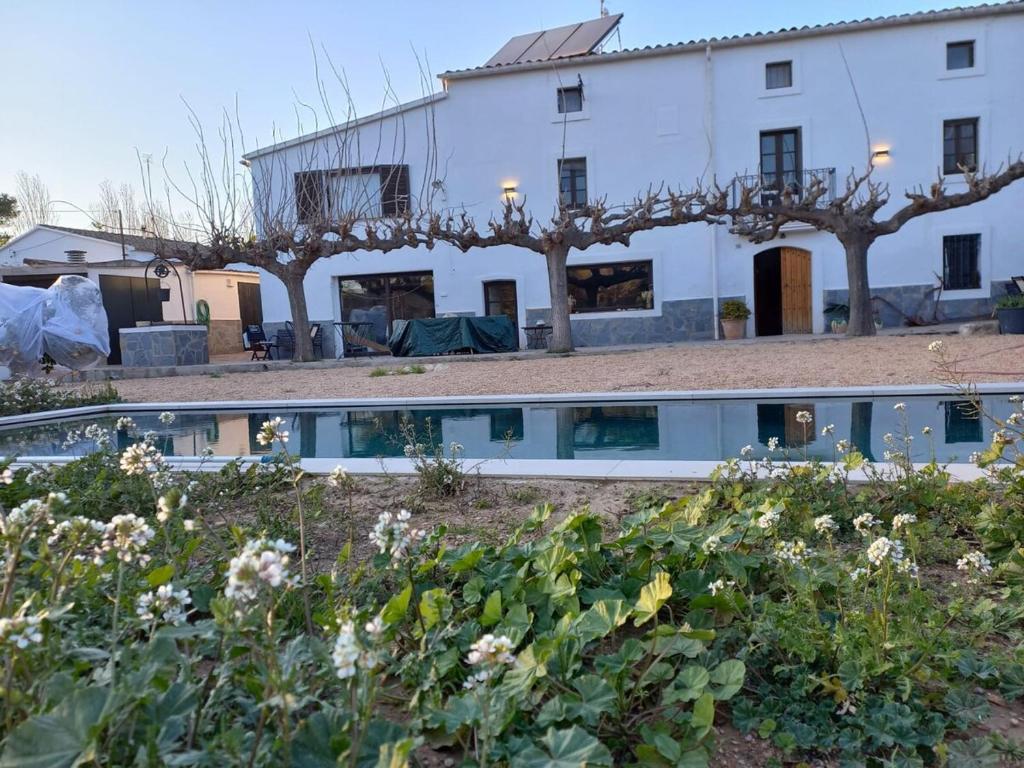 a building with a pool in front of a garden at A Country and Vineyard Retreat in San Martín Sarroca