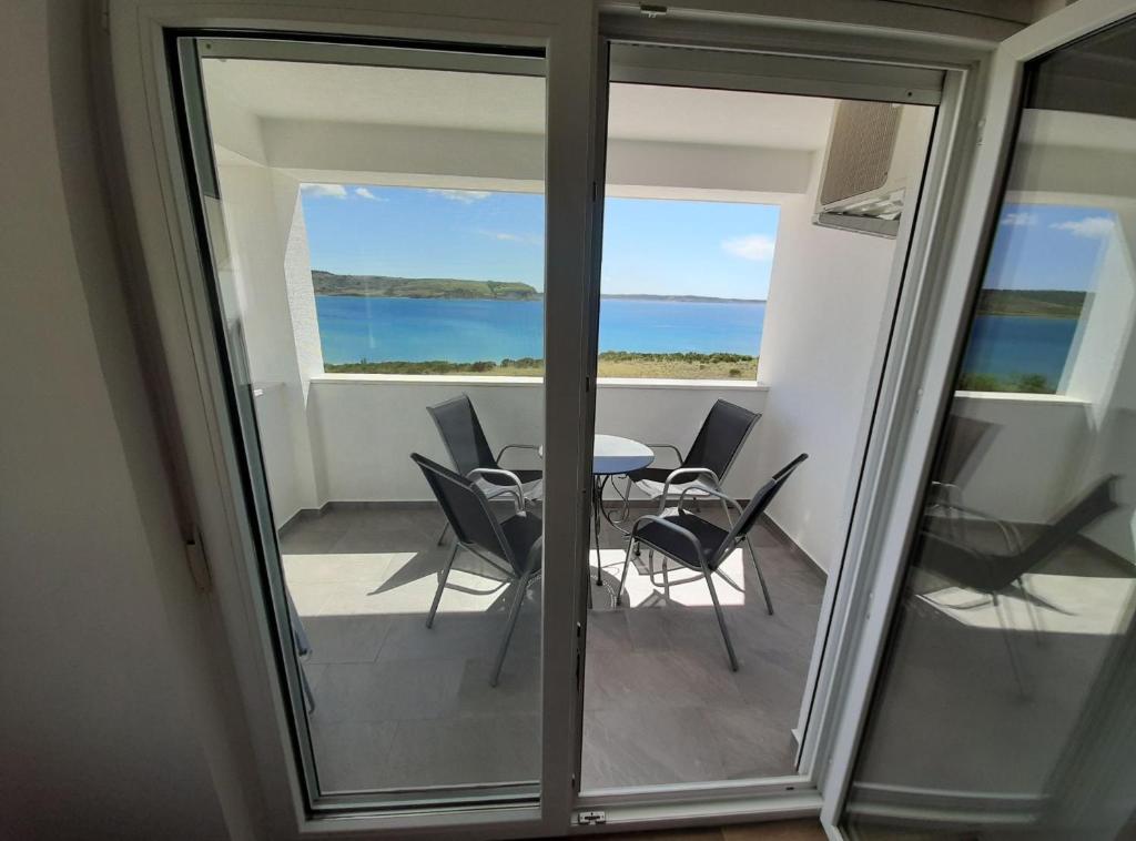 a balcony with a table and chairs and the ocean at Apartments Lana in Zadar