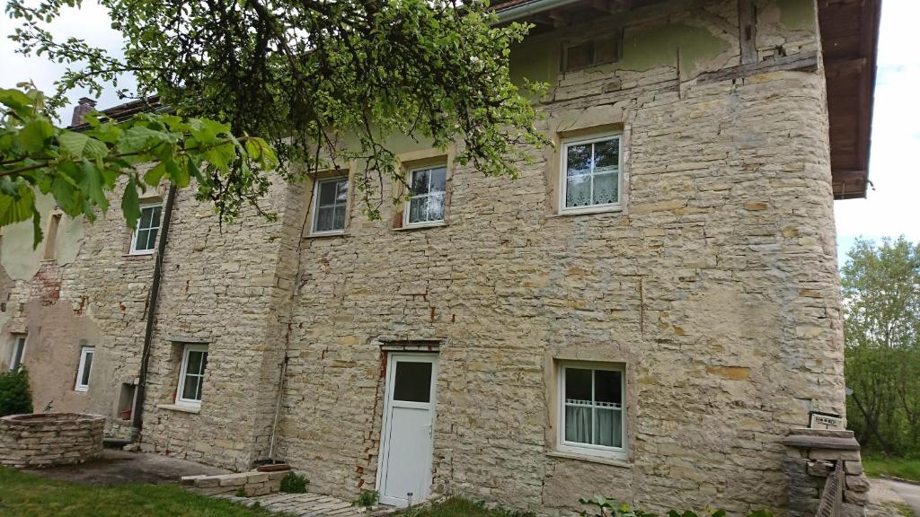 an old stone building with a white door at Jurahaus Solnhofen in Solnhofen