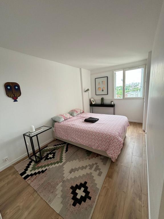 un dormitorio con una cama y una alfombra en Appartement 3 pièces avec parking couvert gratuit., en Le Pré-Saint-Gervais