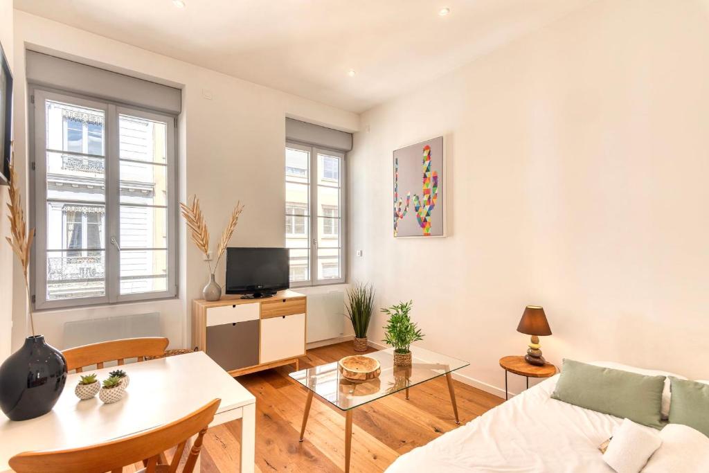 un salon avec un canapé et une table dans l'établissement Le Martini - Clim mobile - studio au Brotteaux Métro B, à Lyon