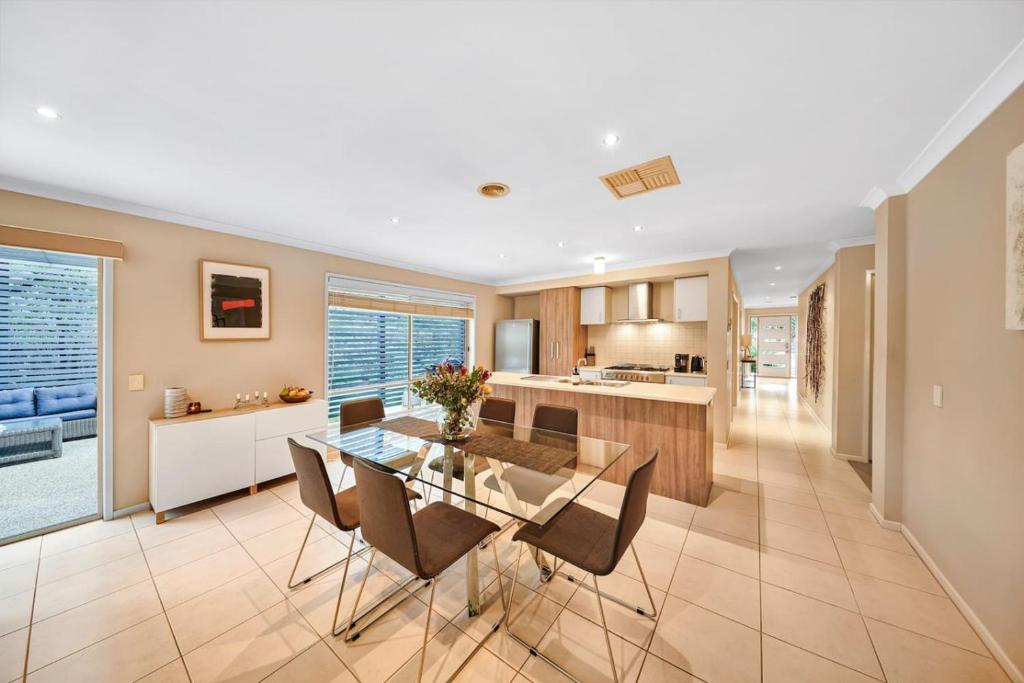 a kitchen and dining room with a glass table and chairs at Ocean Grove retreat in Ocean Grove