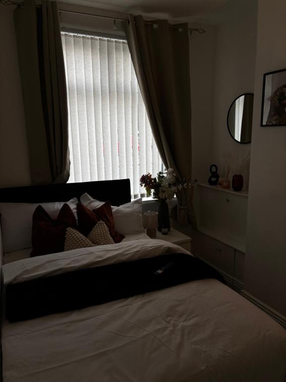 a bedroom with a large bed with a window at Divine Place in Bloxwich