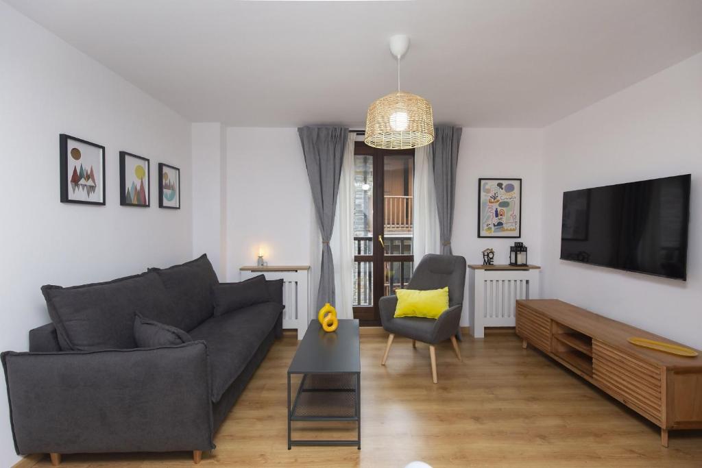 Una sala de estar con un sofá y un televisor. en Casa Real by BeValle, en Escarrilla